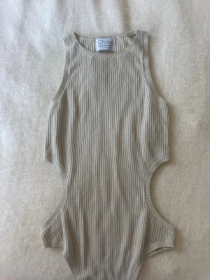 Beige ribbad body från Chloéys - Trendig beige ribbad body från Chloé Shuterman med cut-out detaljer i sidorna. 🩵