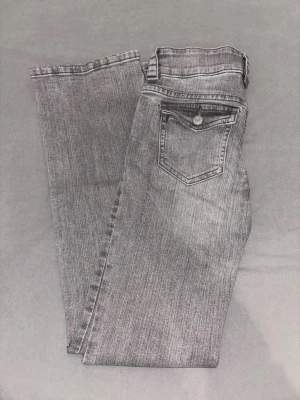Lowwaist bootcut jeans - Snygga lowwaist grå jeans med bootcut passform och klassisk femficksdesign. Jeansen har en cool tvättad look och en ficka med knapp bak. Perfekta för dig som gillar en avslappnad men trendig stil. Måtten rätt över midjan är ca 35cm och innerbenslängden är ca 78cm❤️ Säljer eftersom de inte kommer till användning. Skriv gärna innan ni köper❤️Pris kan diskuteras.