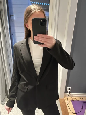 Svart oversized kavaj - Svart kavaj med klassisk krage och knäppning framtill. Modellen är oversized 