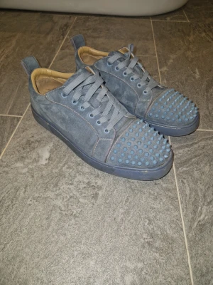 Blåa sneakers med nitar - Priset går att diskuteras. Skorna är använda och är lite slitna men inget man märker när man använder dem. Har tappat bort skolådan till dem