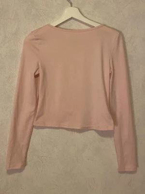 Ljusrosa topp med öppen rygg - Trendig ljusrosa croppad topp med lång ärm och stor öppen rygg. Tillverkad i mjuk bomullsmix som känns skön mot huden. Perfekt för dig som vill ha en enkel men snygg bas i garderoben. Från SHEIN i storlek S💓knappt använd