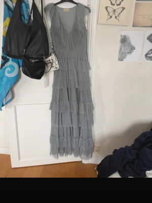 Blå balklänning volang  - Så fin balklänning endast använd 1 gång, jag är 172/173 och den var bra i längden på mig, den är lite grå blå i färgen beroende vilket ljus man är i, varan är lite skadad över dragkedjan och att den har lite bus i sig hehe, vilket jag fotat, väldigt unik och skönt att man kan ha bh under den