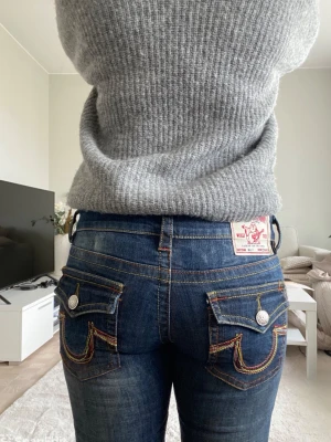 True Religion blå jeans  - Säljer ett par blå jeans från True Religion som inte längre går att få tag på! Jeansen är unika och har dekorativa  sömmar i flera färger på olika ställen (bild 2) 💕. Skriv om ni har några frågor! 