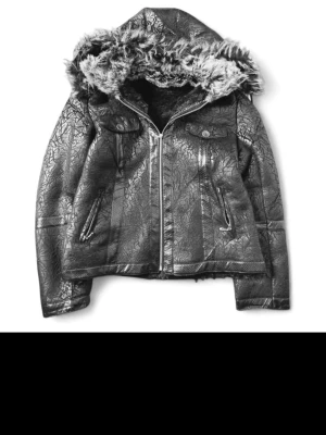 Archive jacka - Snygg svart skinnjacka från Japan. Dragkedja, två bröstfickor med knappar och två snedställda fickor fram. Jackan har en stor huva fodrad med päls i svart och grått Cool struktur på skinnet ger extra edge till din stil. Storlek L men passar bättre som M. Säljer då den inte passar storlek