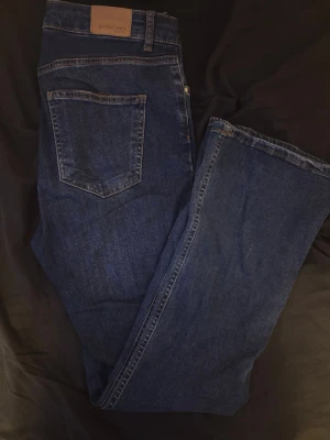 Mörkblå Perfect Jeans från Gina Tricot - Snygga mörkblå jeans från Gina Tricot, modell Perfect Jeans. Klassisk femficksdesign med raka ben och normalhög midja. 