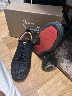 Christian Louboutin svarta sneakers - Loubs skor för 600. Det finns små sakvanser runt om skorna och röda sulan är sliten. 3 spikar är borta. TAR KNGA RETUR. St 40