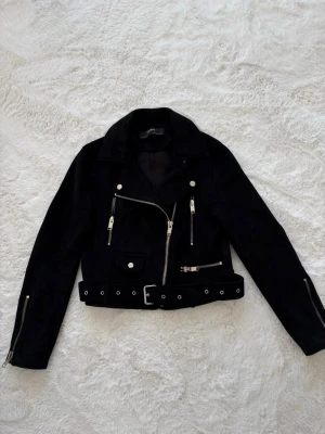 Svart bikerjacka  - Snygg svart bikerjacka från Zara med silvriga detaljer i storlek XS. Jackan är sparsamt använd och i nyskick.