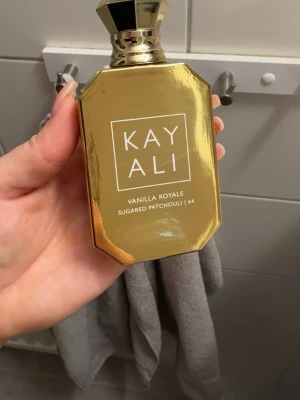 Kayali Vanilla Royale parfym - Lyxig parfym från Kayali. Doften Vanilla Royale Sugared Patchouli 64 har noter av vanilj, rom, crème brûlée, brunt socker, oud och patchouli. Där är lite mer än hälften kvar i flaskan. Jättegod men sträcker mig aldrig efter den längre.