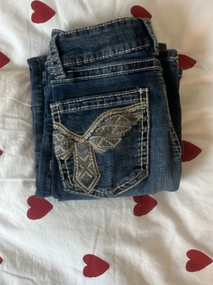 Blåa jeans med broderad bakficka - Ett par mörk blåa jeans som är knappt använda. Säljer eftersom de inte passar och kommer inte till användning.