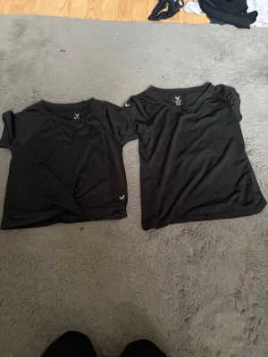 Svarta kortärmade t-shirts från SOC - Två svarta t-shirts från SOC med kort ärm och rund hals. Ena t-shirten har en twistad detalj framtill och den andra har rynkade sömmar på ryggen. Perfekta till träning eller chill. Materialet känns mjukt och stretchigt.💕