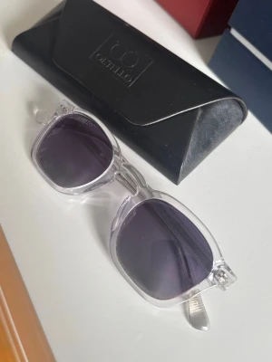 Qetello solglasögon  - Solglasögon med transparenta bågar och tonade glas, väldigt bra skick och kommer med original förpackning