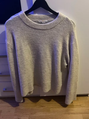 Beige stickad tröja  - Mysig beige stickad tröja från Gina Tricot (Young). Ribbad vid slutet av ärmen och längst ner. Skönt material men sticks lite. Är ungefär storlek M (är 158-164)