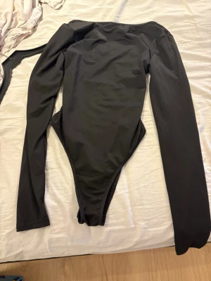 Svart långärmad body med cut-out - Snygg svart body. Den är långarmad. På baksidan har den en ring och den är öppen i ryggen. Använd max 1 gång om ens de