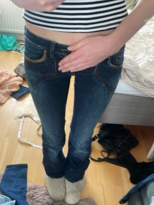 Mörkblå bootcut jeans med låg midja gjord själva  - super Snygga mörkblå bootcut jeans med markerade kontrastsömmar och coola fickdetaljer. Jeansen är väldigt låg midjade och klassisk femficksdesign.anledningen till varför jag säljer jeansen är för att dom har blivit för små för mig och kan tyvärr inte ha dom. gjort dom till bootcut själv, de är inte helt perfekta men dom är inte trasiga på något sätt. jag är 176cm,står i nte storlek tror jag men dom är som en s. jag har också spretat upp dom, hör av dig om du har några frågor eller funderingar💕