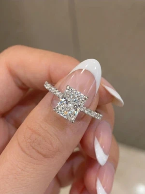 Silverring - Snygg silverfärgad ring med en stor fyrkantig glittrande sten i mitten och små stenar längs hela ringen. Perfekt för dig som gillar bling och vill sticka ut med din stil.