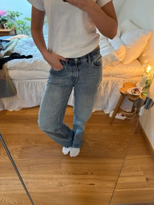 Blå raka jeans - Säljer ett par klassiska blå jeans med rak passform. Jeansen har fem fickor, bälteshällor och stängs med knapp och dragkedja. Perfekta till en enkel t-shirt eller hoodie för en avslappnad look.