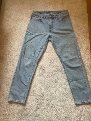 Ljusblå jeans från Vailent - Säljer ett par klassiska ljusblå jeans från Vailent. De har rak passform, fem fickor och gylf med dragkedja och knapp. Tillverkade i slitstark denim, perfekta för en avslappnad och trendig look.