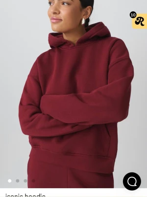 Vinröd  hoodie - Mysig vinröd hoodie i oversized modell med stor huva och magficka. Tillverkad i mjukt bomullsmaterial som känns skönt mot huden. Perfekt för chill dagar eller när du vill ha en avslappnad look. Klassisk design utan tryck eller logga. Lite nopprig inne som ni kan se på bilden 