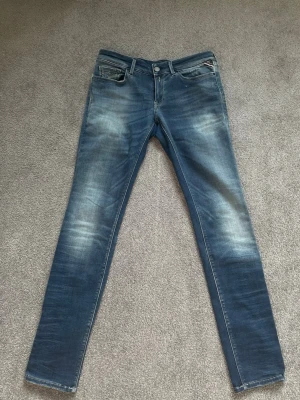 Replay  - Säljer ett par blå slim fit replay jeans med snygga slitningar och tvättade detaljer. 