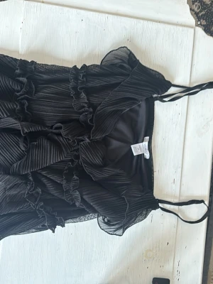 Svart blus - volang svart blus som är stretchig fin och kan variera storlek genom snören. Priset kan diskuteras 🌸