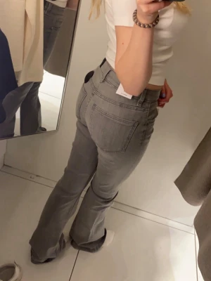 Gråa bootcut jeans  - Dem är uppsydda och passar någon som är runt 160 cm lång. Säljer då dem är för små för mig 