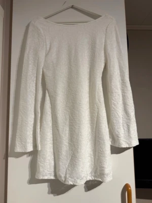 Vit långärmad kortklänning xs - Vit klänning från shein i storlek xs, aldrig använd, säljer 2st likadana, skulle säga att de passar både xs och s då de e stretchigt material.