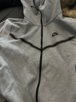 Nike tech fleece - Grå nike tech fleece i herr model storlek m passar mig som är tjej xs en sak på dragkedjan har lossnat men är inget man tänker på