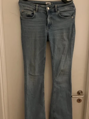 Ljusblå bootcut jeans från lager 157 - Säljer ett par ljusblå bootcut jeans från lager 157 med klassisk femficksdesign och normal midja. Jeansen har en snygg tvättad look och raka ben som går ut lite nedtill. 