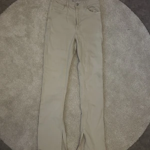 Beiga bootcut byxor från Zara - beiga byxor från Zara. Byxorna har normal passform med bootcut ben och slits längst ner. Liten fläck på ena fickan men inget man tänker. 