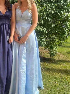 Ljusblå långklänning med v-ringning - Jätte fin klänning! Använd 1 gång. Prislapp kvar. Storlek S. Jag är 170cm lång. 