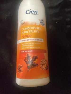 Cien Papaya Conditioner Hair Fruits - Balsam från Cien med papayadoft, speciellt för torrt hår. Innehåller 97% ingredienser av naturligt ursprung och är veganskt. Flaskan är vit med orange etikett och papayamotiv. Ger näring och stärker håret utan att tynga ner.