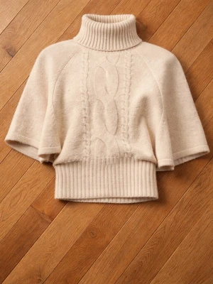 Beige stickad polotröja med kort ärm - Säljer en beige stickad polotröja med korta ärmar och bred ribbad mudd i midjan. Tröjan har ett klassiskt flätmönster framtill och hög polokrage. Perfekt för lager på lager och riktigt snygg till jeans eller kjol.