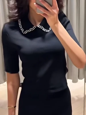 Svart topp med pärlkrage från H&M - Snygg svart topp från H&M med korta ärmar och en unik krage dekorerad med pärlor. Materialet känns mjukt och bekvämt.