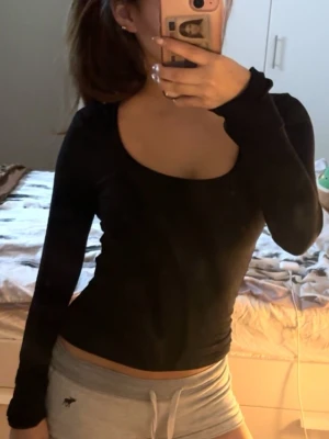 Svart långärmad topp med rund hals - Säljer en svart långärmad topp med rundad halsringning. Modellen är tight och enkel, perfekt att styla med olika outfits. Toppens material känns mjukt och stretchigt, vilket gör den bekväm att bära hela dagen.