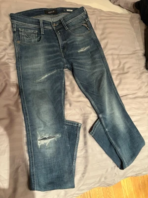 Replay Anbass Jeans - Säljer dessa blåa Replay Anbass jeansen med snygga slitningar på båda benen. Dem är i storlek W29 L32. Jeansen är i toppenskick och är knappast använda, väl omhändertagna. Skriv ifall ni har frågor angående mått eller fler bilder. 