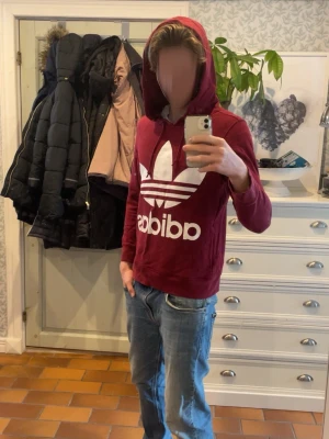 Vinted vinröd Adidas hoodie - Snygg Vinted vinröd hoodie från Adidas med stor vit Trefoil-logga på bröstet. Klassisk modell med huva och ribbade muddar vid ärmslut och nederkant. Mjuk bomullskänsla och perfekt för en avslappnad streetwear-look. Strl: S, vid frågor och funderingar skriv gärna!