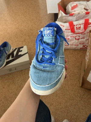 Nike Book 1 Denim/Blå sneakers - Unika Nike Book 1 basket skor storlek 47,5 i denim och blått tyg med fransiga kanter och vita detaljer. Skorna har blå skosnören och en vit sula. Märket syns tydligt på plösen och insidan. Perfekta för dig som vill sticka ut med en cool och trendig look.  Använder inte de mer då jag köpte nya skor. pris kan diskuteras. Det kan även passa 46 till fyrtiosex och en halv i skostorlek.