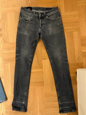 Dondup jeans - Snygga mörkgrå slim fit jeans från Dondup med diskreta slitningar från fabriken. Jeansen har en smal passform och är tillverkade i stretchigt denimtyg för extra komfort. Inte särskilt använda och rätt bra skick