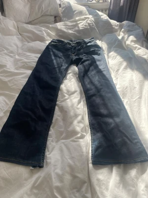 Bootcut jeans  - Ett par mörkblåa bootcut jeans från Lee. Skulle inte säga att dom är lågmidjade på mig men dom är inte högmidjade. Jag kunde inte hitta någon storlek men skriver måtten här nedan☺️💕                                      Midja rakt över-38 cm                                       Innerbens längd-77 cm                                    Ytterben-103 cm                                                   Gren-20 cm