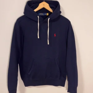 Nyskick! Ralph Lauren Mörkblå Hoodie - Säljer denna feta Hoodie, Enbart använd 5 gånger. Storlek S, passar som en liten S eller XS. Nypris omkring 2400, säljer till lite mindre än hälften ungefär. Passa på och köp för bättre skick på en Ralph Lauren Hoodie än detta kommer ni ej hitta. Hör gärna av er vid funderingar🙌💙