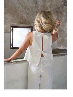 Vit top med rosettdetalj i ryggen - Vit linnetop från Nakd, köpt för ca 2 år sen men använd endast en gång. Superfin till sommaren. Kunde inte hitta mer bilder från hemsidan då den inte säljs hos nakd längre 