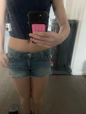 Blå jeansshorts - Säljer ett par blå jeansshorts med fransig kant och slitna detaljer. Säljer för att de inte kommer till användning💗