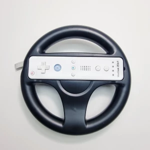 Nintendo Wii Wheel / Ratt - Svart ratt till Nintendo Wii, perfekt för racing-spel. Ratten är tillverkad med plats för Wii Remote i mitten. Passar till alla Wii-konsoler och är smidig att hålla i. (Wii remote på bilden är som visningsexempel, medföljer ej)