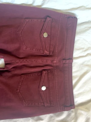 Vinröda Bootcut Jeans  - Säljer ett par snygga lågmidjade+Bootcut jeans, vinröda !!💗💗 Använda en gång 