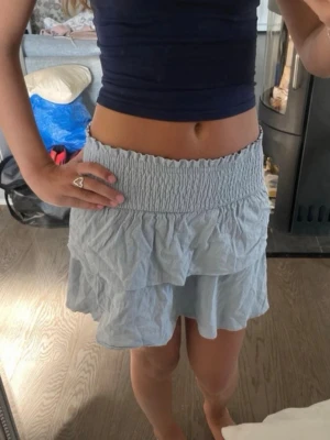 Ljusblå volangkjol från SHEIN - Supersöt ljusblå kortkjol från SHEIN med bred smock i midjan och dubbla volanger. 