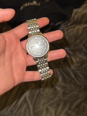 Silverfärgad klocka från AX Armani - Stilren klocka från AX Armani i silverfärgat rostfritt stål med klassisk rund urtavla och datumvisning. Länken är polerad och ger en elegant look. Perfekt accessoar för dig som gillar tidlös design.