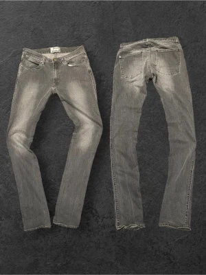 Grå Acne Studios jeans - Snygga grå jeans från Acne Studios i slim fit-modell. Jeansen har klassisk femficksdesign, normalhög midja och smala ben. Tillverkade i mjukt denimtyg med lätt tvättad look och subtila slitningar för en trendig vibe.