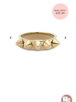 Guldring från Edblad - Cool ring i guldfärgad metall med fem konformade nitar runt hela bandet. Ringen har en modern och edgy design som sticker ut och passar perfekt för dig som gillar statement-smycken.