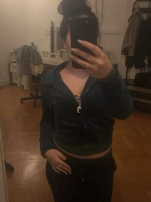 Mörkgrön croppad hoodie med dragkedja - Mörkgrön croppad hoodie med dragkedja framtill och huva. Hoodien har en slim passform och är tillverkad i mjuk sammet, perfekt för en trendig och bekväm look. ( pris kan diskuteras) 