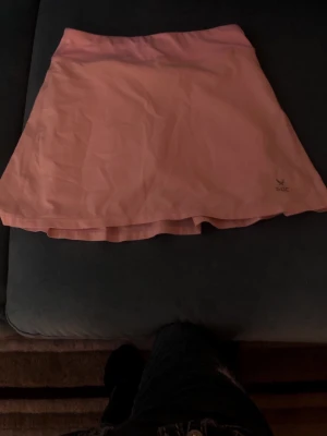 Ljusrosa skort från SOC - Snygg ljusrosa skort från SOC med bred linning och lätt utställd passform. Kjolen har plisserade detaljer baktill och är tillverkad i ett mjukt, stretchigt material som passar perfekt för en aktiv livsstil.